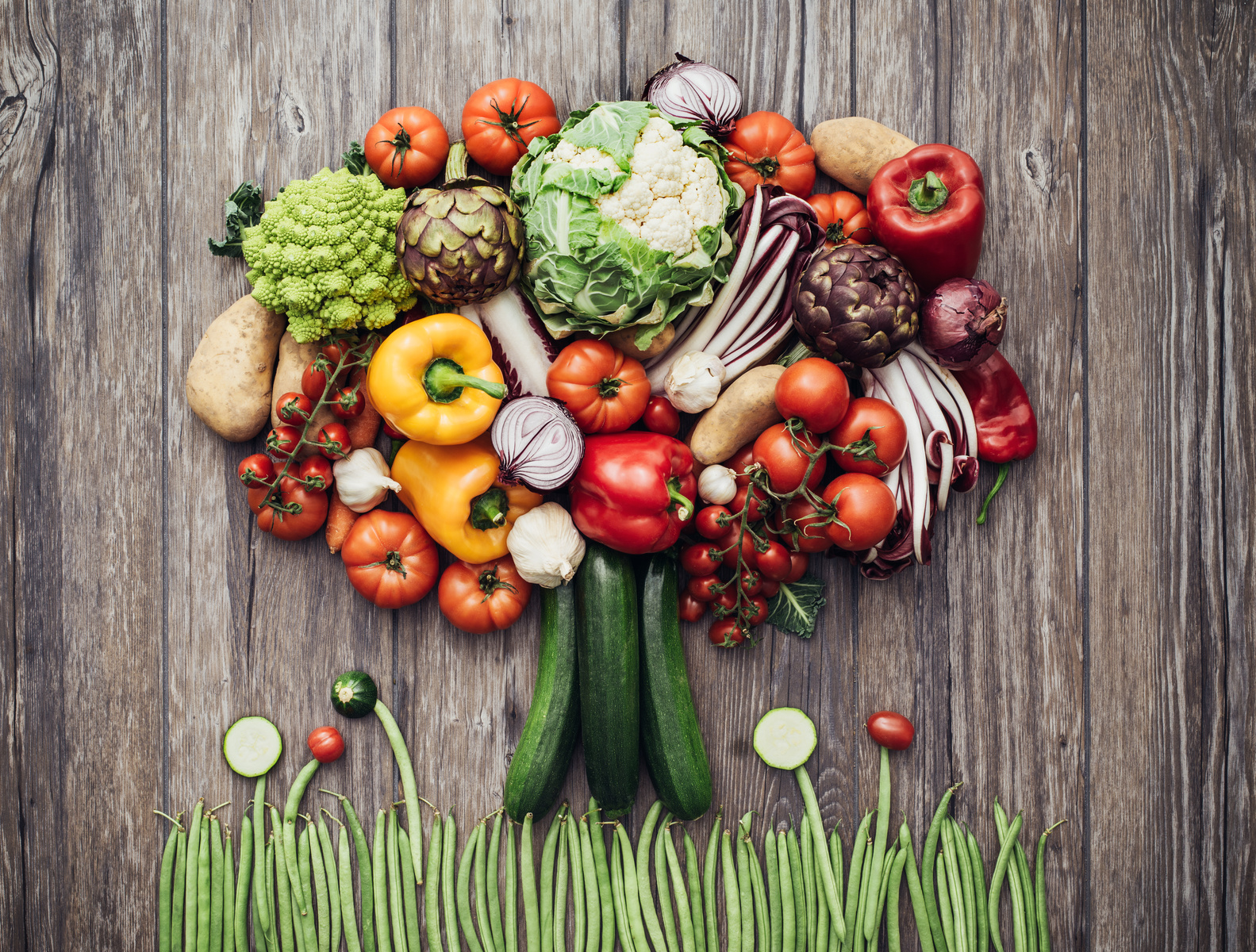 Colorful lush tree made of freshly harvested organic vegetables on a rustic wooden worktop, nutrition and nature concept